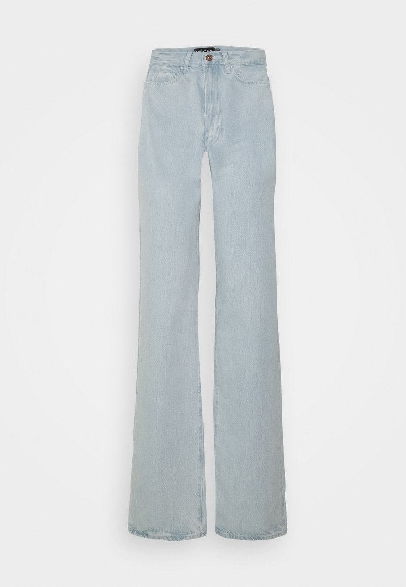 Jeans de brim de corte flare em azul claro. Apresentam uma cintura alta e um desgaste subtil, com um único botão frontal e cinco bolsos.
