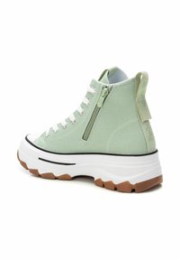Zapatilla alta de lona verde menta con suela blanca y acentos de goma texturizada. Cuenta con un zipper lateral y un ribete negro en contraste.