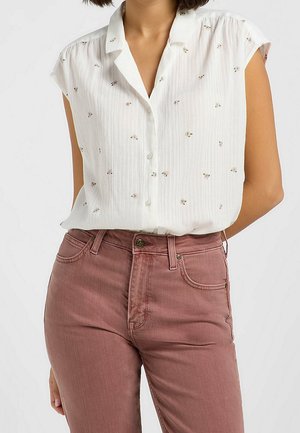 Witte korte mouw blouse met een button-down kraag, voorzien van een gestructureerd streeppatroon en kleine bloemrijke borduursels; gecombineerd met rozenkleurige spijkerbroeken.