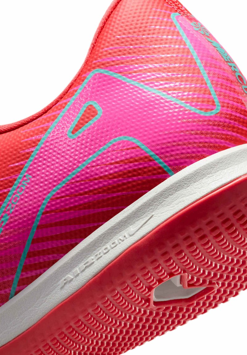 Czerwono-różowy but sportowy z fakturowaną cholewką, odważnymi geometrycznymi akcentami i białą gumową podeszwą z wzorzystą bieżnią dla lepszej przyczepności.