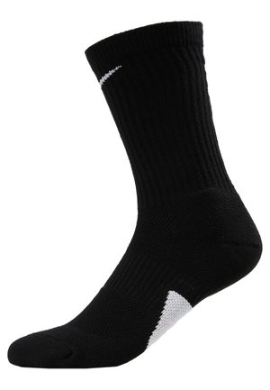 Calzino sportivo nero con texture a costine, lunghezza alla caviglia, punta rinforzata e dettaglio del logo bianco vicino alla parte superiore.