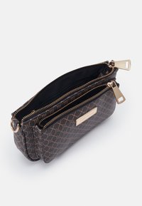 Brun mönstrad zip-väska med två fack, gyllene detaljer och en logotavla på sidan. Slät yta och rektangulär form.