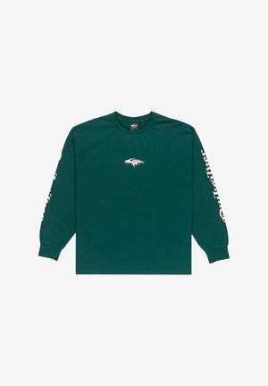 Chemise à manches longues en coton vert foncé avec un col rond, présentant un logo blanc sur le devant et un texte blanc le long de la manche gauche.