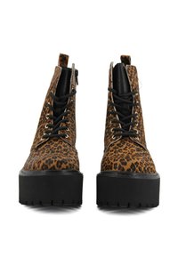 Stivali alla caviglia stampa leopardata con suola nera spessa, dotati di lacci neri e zip laterale per una facile vestibilità. Superiori in tessuto testurizzato.
