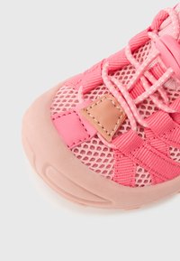 Αθλητικό παπούτσι σε ανοιχτό ροζ με αεραγωγό επάνω μέρος από διχτυωτό ύφασμα, ελαστικά κορδόνια, λαστιχένια σόλα και ταμπά διακοσμητικό σημείο στο πλάι.