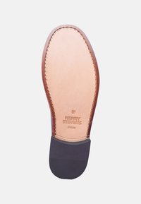 Suola di scarpa in pelle con una parte superiore liscia color tan, tacco in gomma scuro e marchio impresso "HENRY STEVENS BERLIN". Dettaglio con cucitura sul bordo.