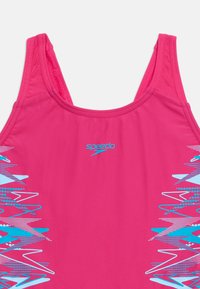 Φωτεινό ροζ επάνω μέρος μαγιό Speedo με μπλε και λευκά γεωμετρικά σχέδια στις πλευρές και χοντρές ράντες ώμων.