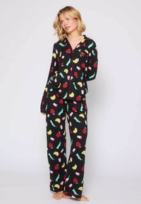 Schwarz gestreiftes Pyjama-Set mit einem Muster aus roten, gelben und grünen Lebensmitteln und Getränken. Lockere Passform mit einem knöpfbaren Oberteil und langen Hosen.