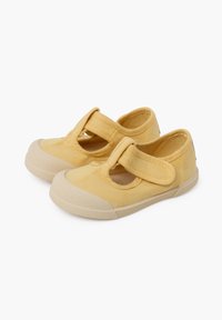 Geel canvas Mary Jane schoenen met een klittenbandsluiting, ronde neus en een gestructureerde rubberen zool. Heeft een uitsnijontwerp boven de teen.