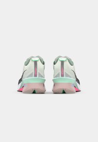 Des chaussures de course avec une tige en mesh blanche et grise, des accents verts et une semelle multicolore avec des éléments roses et menthe.