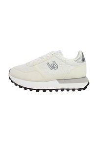 Scarpe sportive bianche realizzate con materiali in rete e sintetici, con una suola grigia, tacchetti neri per la trazione e un accento metallico sul tallone.