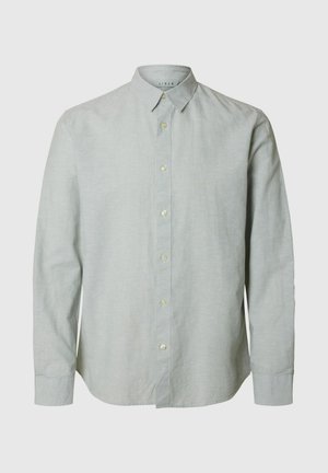 Hele roheline linane särk pikkade varrukatega, nupuga krae ja ees nupuga sulgemine. Sile tekstuur, tavaline lõige ja ümar serv.