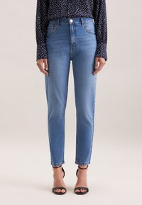 Jeans azzurri a vita alta, slim fit e lunghezza alla caviglia, con una texture liscia e un design classico a cinque tasche.