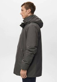 Parka isolata grigia con cappuccio, dotata di una zip frontale e tasche laterali, dalla texture liscia e design di media lunghezza, mostrata di lato.