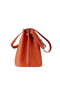 Orange läderhinkväska med texturerad yta, justerbar axelrem och en dragskoöppning upptill. Inga synliga metallaccenter.