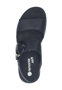 Sandalo nero con due cinturini regolabili, caratterizzato da un grande accentuato circolare e una soletta morbida. Materiale in pelle liscia, design a suola piatta.