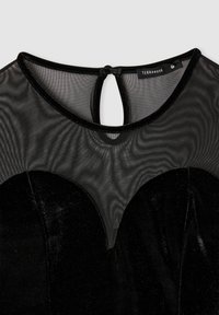 Abito nero con una sezione inferiore in velluto e una parte superiore in rete trasparente, dotato di un dettaglio a oblò sulla schiena. Etichetta che recita "Terranova."