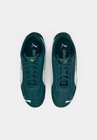 Baskets en daim bleu sarcelle avec des accents blancs, des lacets plats et une languette rembourrée. Dotées d'un logo doré et d'un design texturé sur les côtés.