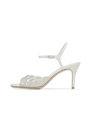 Sandalo bianco con tacco alto caratterizzato da un design floreale a taglio con dettagli in strass sulla parte anteriore e una sottile cintura alla caviglia regolabile.