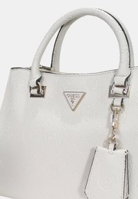 Borsa bianca con texture e motivo floreale in rilievo, hardware argentato, manici superiori e ciondolo removibile. Placca con logo sul davanti.