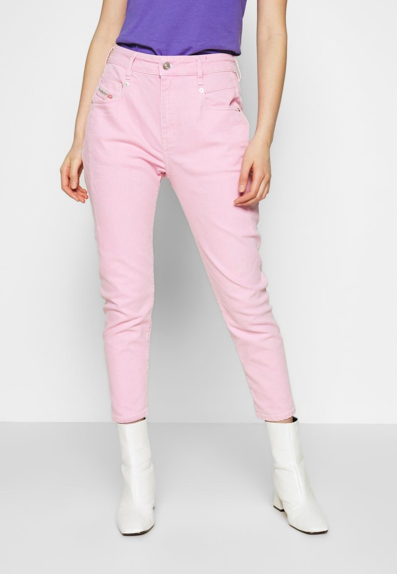 Rosa bomullsjian med smal passform, hög midja, framfickor och silverdetaljer. Matchas med vita ankelstövlar.