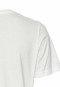 Hvid bomulds T-shirt med korte ærmer og rund halsudskæring. Glat tekstur med en standard pasform og syninger langs kanten og ærmerne.