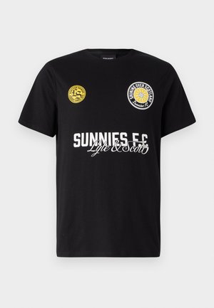 Tricou negru din bumbac cu două logo-uri circulare pe piept. "Sunnies FC" este imprimat cu litere albe, îndrăznețe, având accente cursive dedesubt.