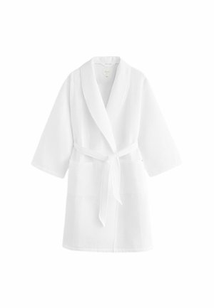 White bathrobe made of textured cotton with a shawl collar, three-quarter sleeves, two front pockets, and a matching tie belt.