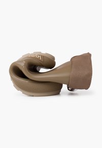 Produit en silicone flexible marron avec une prise texturée, comportant un bel accent en tissu rembourré et une base en caoutchouc durable, conçu pour le confort.
