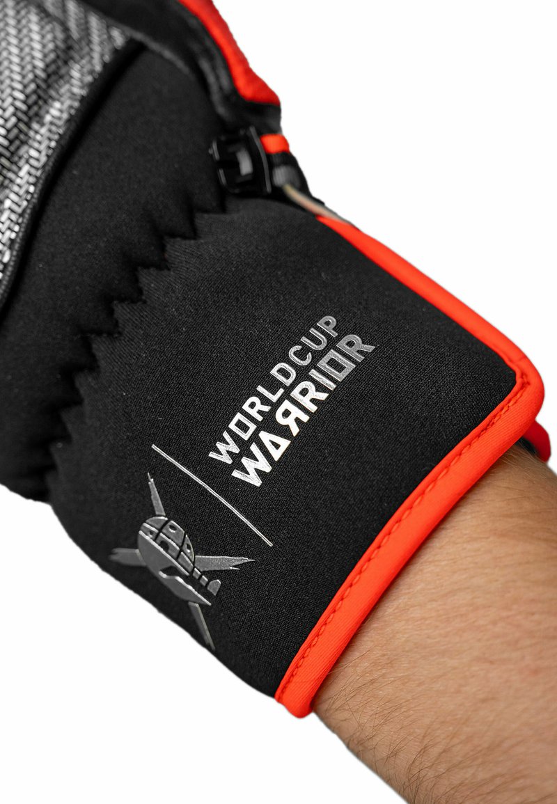 Schwarze Handschuhe mit orangefarbenen Akzenten, die ein strukturiertes Design und ein Logo mit der Aufschrift "WELTMEISTERSCHAFT KRIEGER" aufweisen. Reißverschlussdetails sind an der Seite sichtbar.