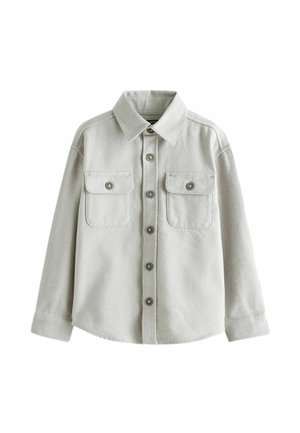 Chemise gris clair à manches longues avec boutons, deux poches poitrine boutonnées et col pointu, présentée sur fond blanc.