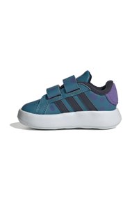 Zapatillas infantiles en azul y verde con un patrón de lunares, dos tiras de velcro, rayas azul marino y un acento en el talón de color púrpura.