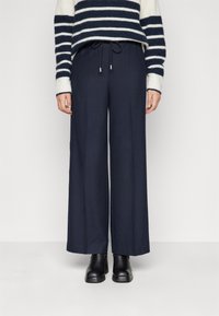 Breda marinna byxor i mjukt tyg med dragsko i midjan och framfickor. Matchas med en randig stickad tröja.