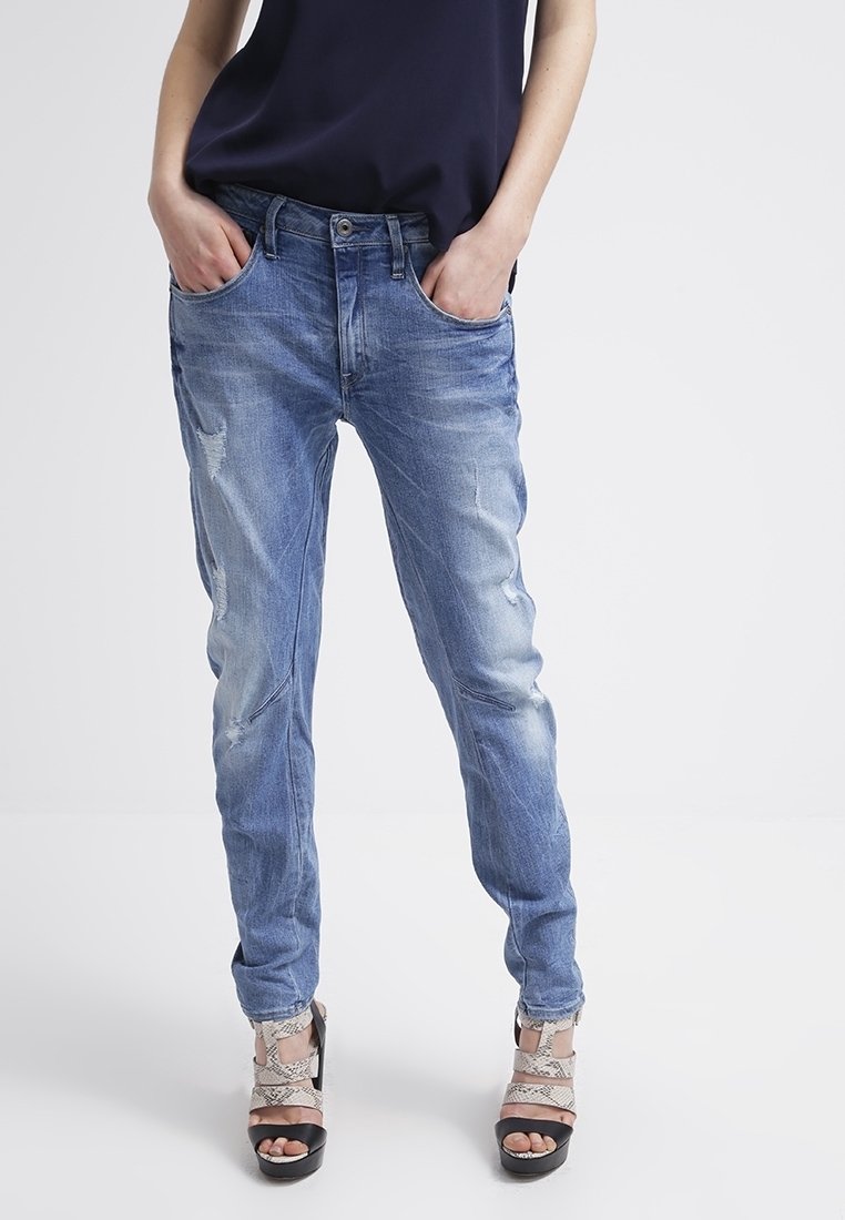 Ljust blå denimjeans med en avslappnad passform, med slitna detaljer och fem fickor. Matchas med svarta och ormtryckta stilettklackar.