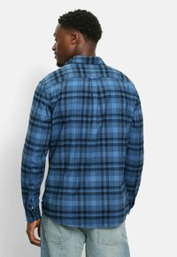 Blau karierte Hemd mit einem ausgeprägten Karomuster, langärmlig und mit klassischem Kragen. Hergestellt aus weichem Stoff, der eine auffällige Rückendetail zeigt.