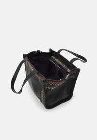 Černá kožená taška přes rameno s dvěma uchy, vícerozměrnými vyšívanými detaily a otevřeným vrchem, který odhaluje fialovou látkovou podšívku s kapsou na zip.