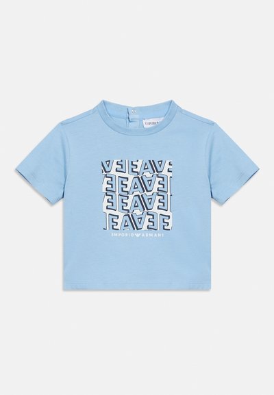 Φωτεινό γαλάζιο παιδικό μπλουζάκι με κοντά μανίκια, με τετράγωνο σχέδιο από παραμορφωμένα λογότυπα "EA7" και κείμενο "EMPORIO ARMANI" κάτω από το σχέδιο.