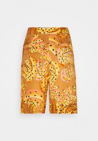 Short orange taille haute avec motifs abstraits de bananes en jaune, noir et rose, avec poches frontales et ourlets cousus.