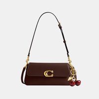 Bolso de hombro de cuero marrón oscuro con cierre dorado en forma de "C" y un colgante en forma de cereza en oro y rojo colgando en el lado derecho.