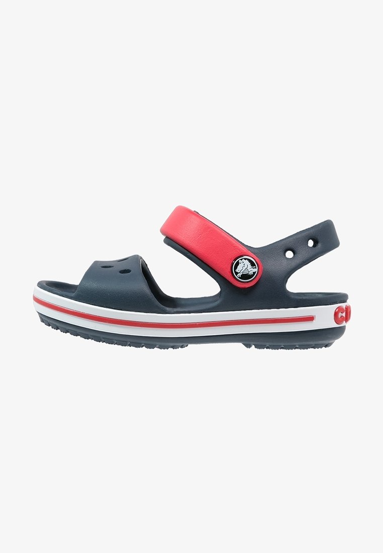 Blue and red sandal with a strap, made from flexible material. Features ventilation holes, white and red stripes, and a round logo accent.
