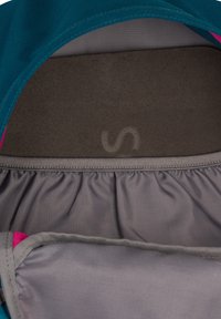 Notranji pogled nahrbtnika, ki prikazuje sivo elastično žep in rjav oblazinjen hrbtni panel s svetlo oznako velikosti "S".