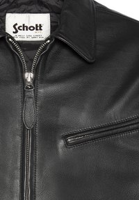 Veste de moto en cuir noir avec fermeture éclair, doublure intérieure matelassée et poche poitrine zippée ornée d'accents en métal argenté.