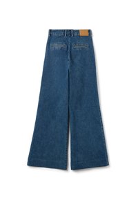 Pantalones de mezclilla de pierna ancha en azul oscuro con un acabado texturizado, que cuentan con dos bolsillos traseros y un parche de cuero marrón en la cintura.