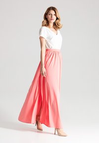 Maxikleid mit weißem Oberteil und einem fließenden koralfarbenen Rock aus leichtem Stoff, mit elastischem Bund und V-Ausschnitt.