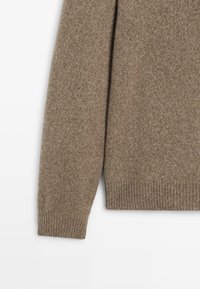 Bruine gebreide trui met een gestructureerde afwerking, lange mouwen en geribde manchetten en zoom voor een snug fit.