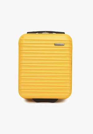 Valigia rigida gialla con texture rigata, chiusura con zip, dettagli neri e un logo prominente sul davanti. Forma compatta e rettangolare.