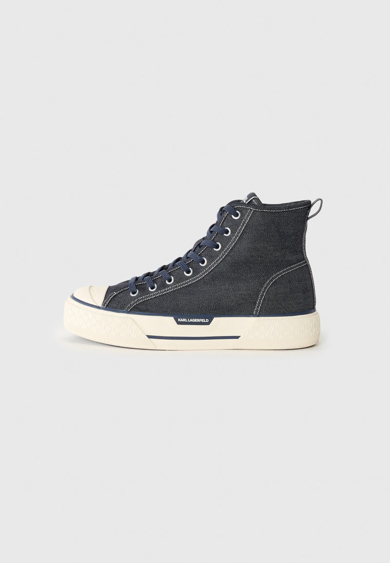 Høye sneakers laget av mørk denim med en kremfarget gummisåle, pyntet med marineblå snørebånd og en bakre trekksløyfe. Logo på siden.