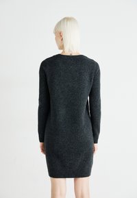 Vestido de suéter cinza escuro com mangas longas, punhos e barra canelados, feito de um tecido de malha texturizada. Decote redondo simples e silhueta ajustada.