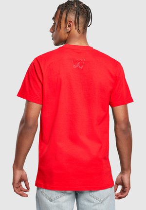 Red cotton t-shirt featuring short sleeves and a crew neck. Distinctive graphic printed on the upper back in white. Casual fit.