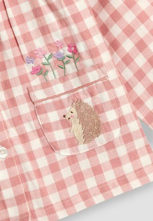 Ružovo-biely kockovaný košeľový top s vyšitým ježkom na vrecku, s kvetinovým vyšívaním nad ním. Mäkká tkanina s gombíkovým zapínaním.